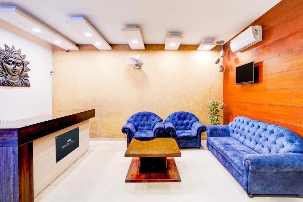 ein Wartezimmer mit blauen Stühlen und einer Couch in der Unterkunft Townhouse Prince Chowk Near Railway Station in Dehradun