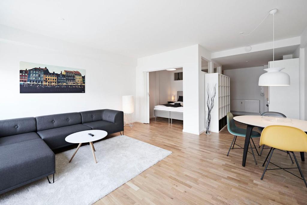 a living room with a couch and tables and a bedroom at Cool 1-bed with private terrace in Copenhagen