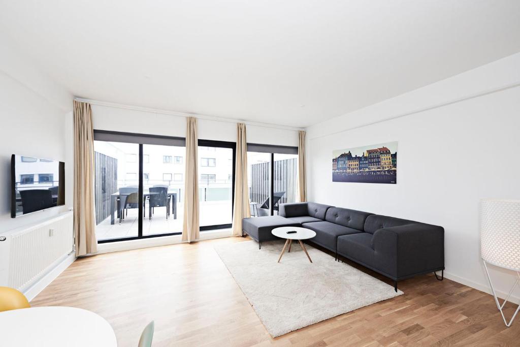 a living room with a couch and a table at Cool 1-bed with a private terrace. in Copenhagen
