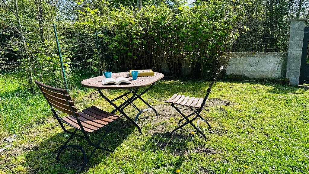une table et deux chaises dans la cour dans l'établissement La little white house, à Cayeux-sur-Mer