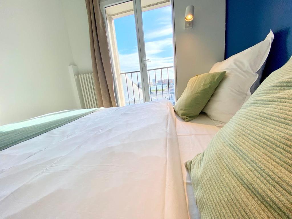 Кровать или кровати в номере L'Escale Appartements et Suites en bord de Mer