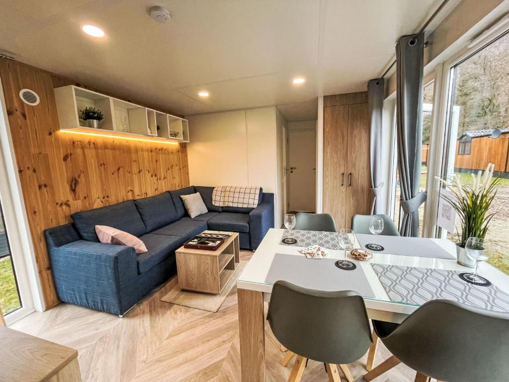 a living room with a blue couch and a table at Holiday Home Tiny Haus Christas Angler-Oase by Interhome in Riedenburg