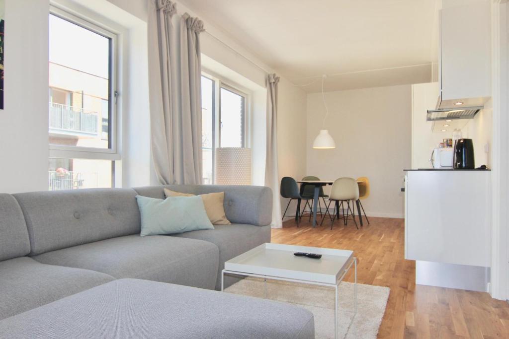 a living room with a couch and a table at Fantastic 1-bed w balcony in Ørestaden in Copenhagen