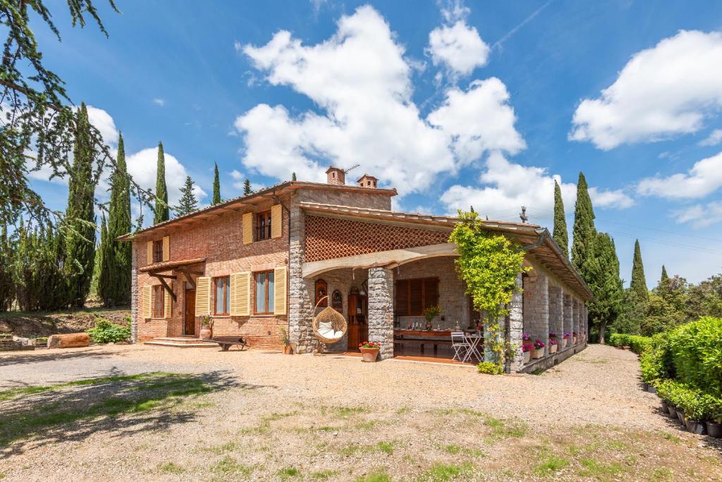 an exterior view of a house with trees at Vertine Countryside in Gaiole in Chianti