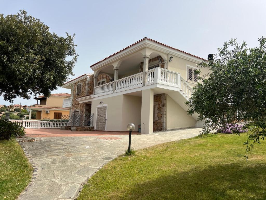 a large white house with a balcony on a driveway at Villa Maccioni in Budoni