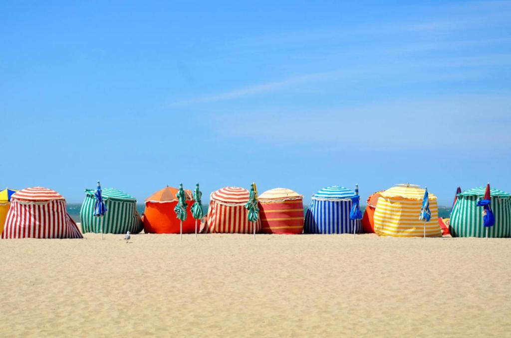 un groupe de cerfs-volants colorés assis sur la plage dans l'établissement Sweet villa au vue à mer, à Trouville-sur-Mer