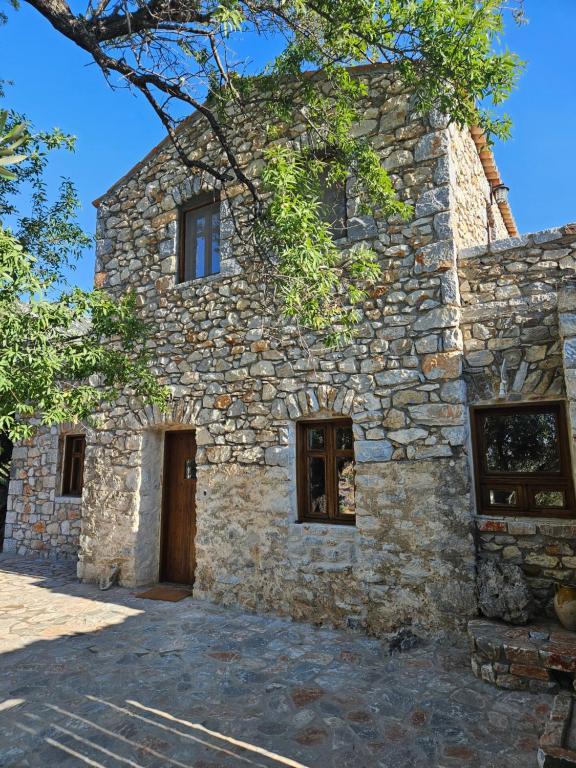 an old stone building with a door and windows at Casa Tsiliviani in Loukádhika