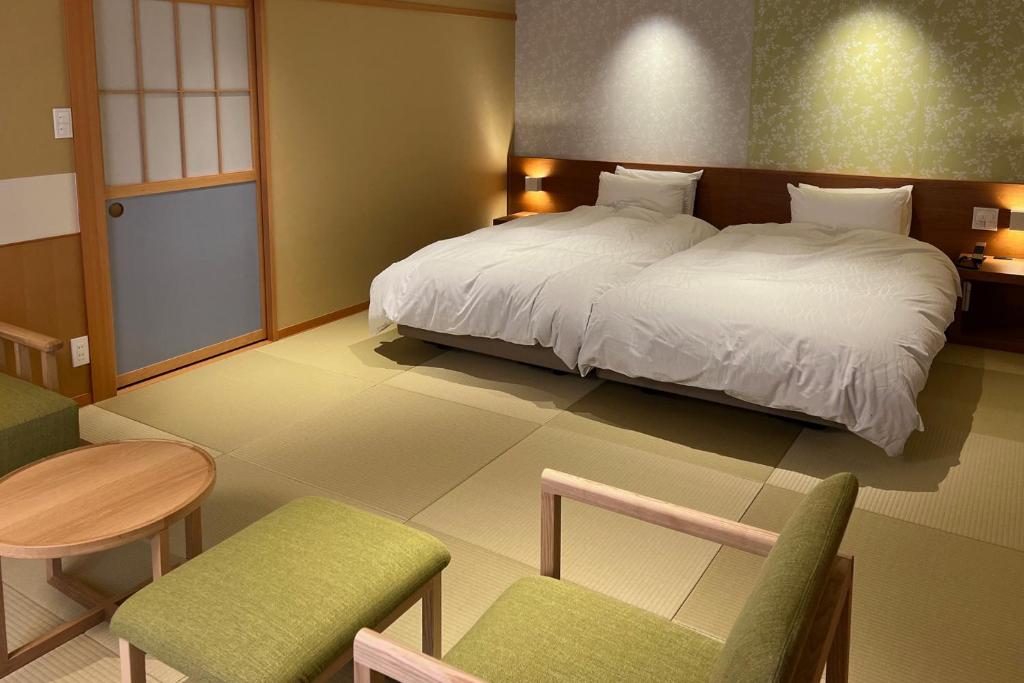 Postel nebo postele na pokoji v ubytování Akaishiya 城崎温泉旅館 赤石屋