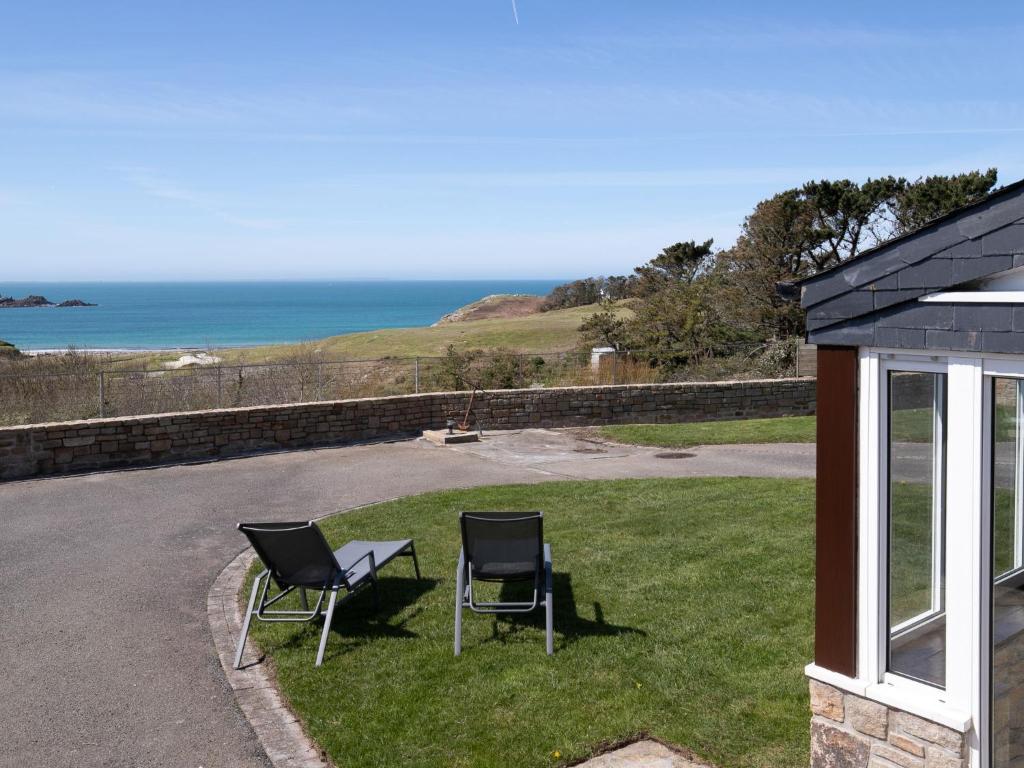 - deux chaises et une table dans une cour donnant sur l'océan dans l'établissement Holiday Home Blaues Meer by Interhome, à Rubian