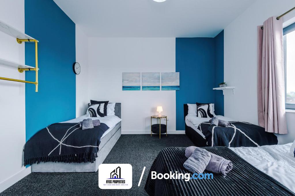 two beds in a room with blue walls at 25 percent OFF Monthly Stay By NYOS PROPERTIES Short Lets & Serviced Accommodation Manchester Business Leisure in Manchester
