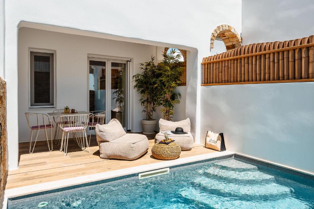 a house with a swimming pool and a patio at Sunday Luxury Suites in Agia Anna Naxos