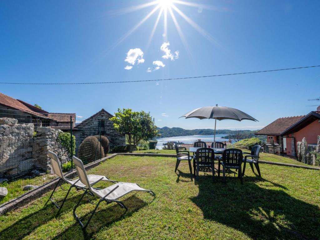 une table et des chaises avec un parasol dans l'herbe dans l'établissement Holiday Home Monte San Giulio by Interhome, à Pella