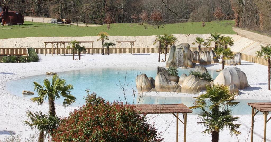 - une piscine dans un parc planté de palmiers dans l'établissement Village Vacances - DéfiPlanet', à Dienné