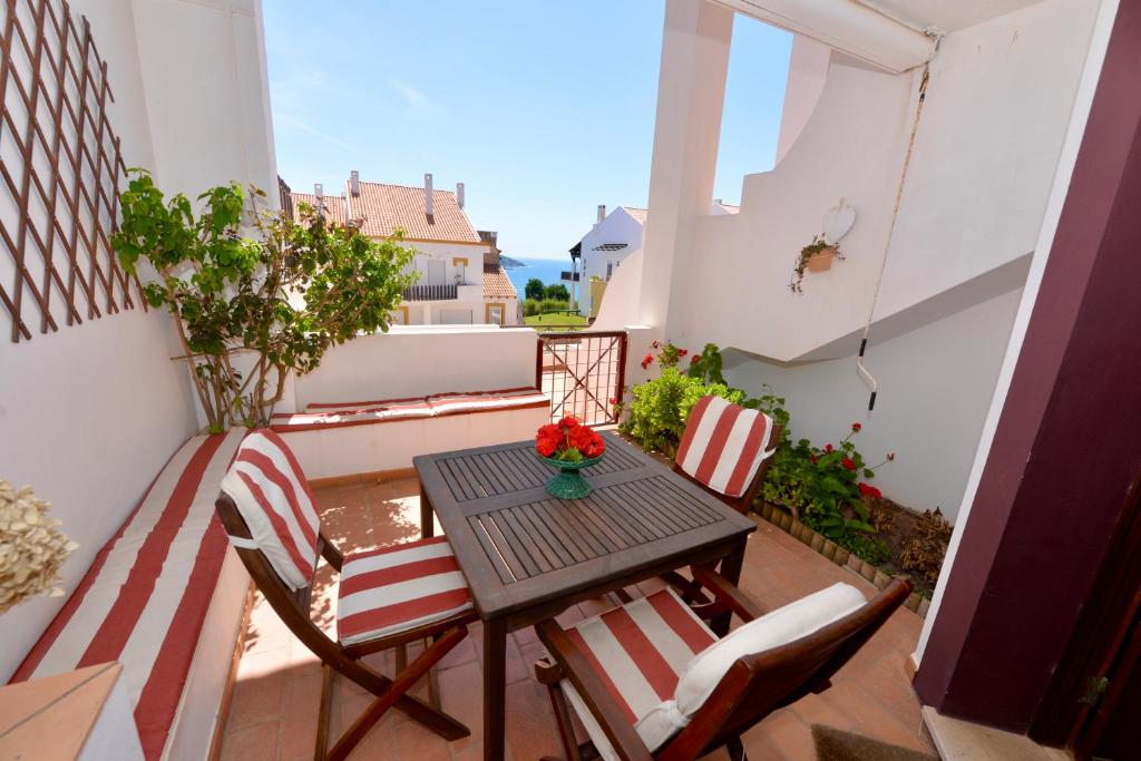 a small balcony with a table and chairs at Paddle - Sea view apartment with 3 pools, tennis & squash court in São Martinho do Porto