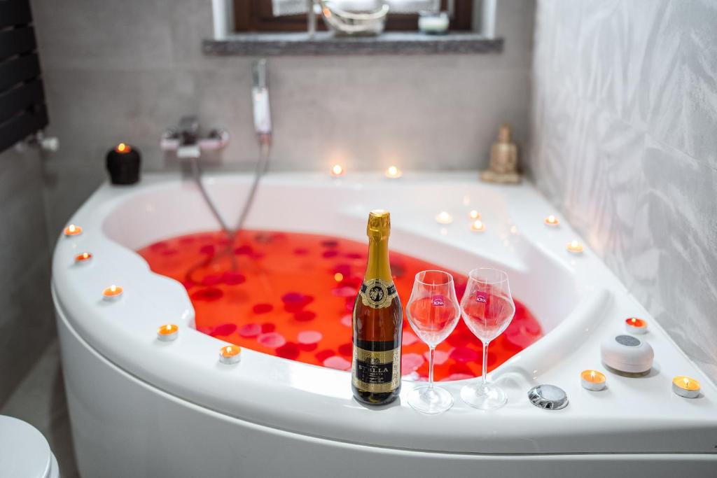 a bath tub with two wine glasses and a champagne bottle at Idromassaggio Doppia - Dimora Zen Seregno in Seregno