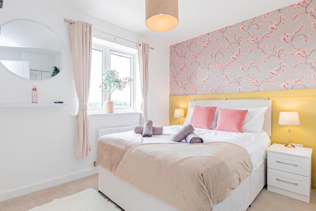 a bedroom with a large bed with pink walls at Luxurious House with Free Parking 