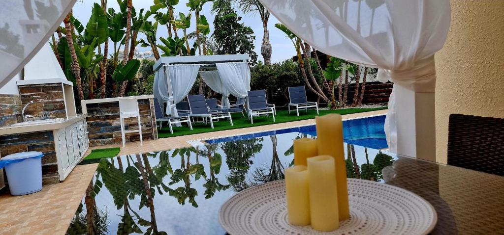 a pool with a table with candles in front of it at Gabriel Villa in Protaras