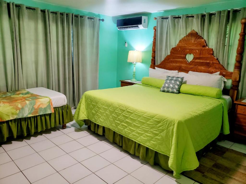 een slaapkamer met een bed met een groen dekbed bij 237 Bratton Avenue in Montego Bay