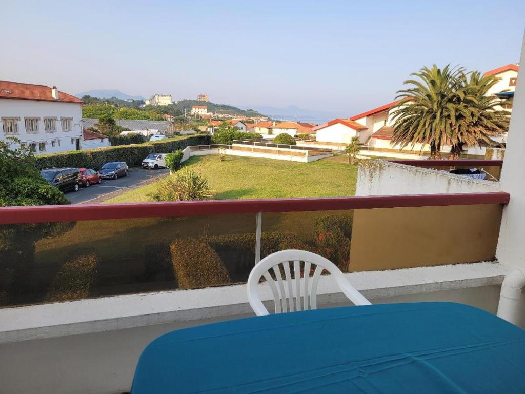 une table bleue et une chaise blanche sur un balcon dans l'établissement Biarritz Milady, à Biarritz