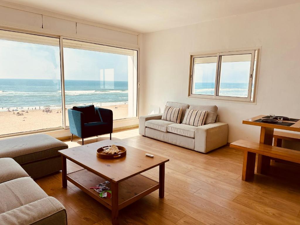 uma sala de estar com vista para a praia em Villa vue imprenable sur l’Océan. em Moulay Bousselham