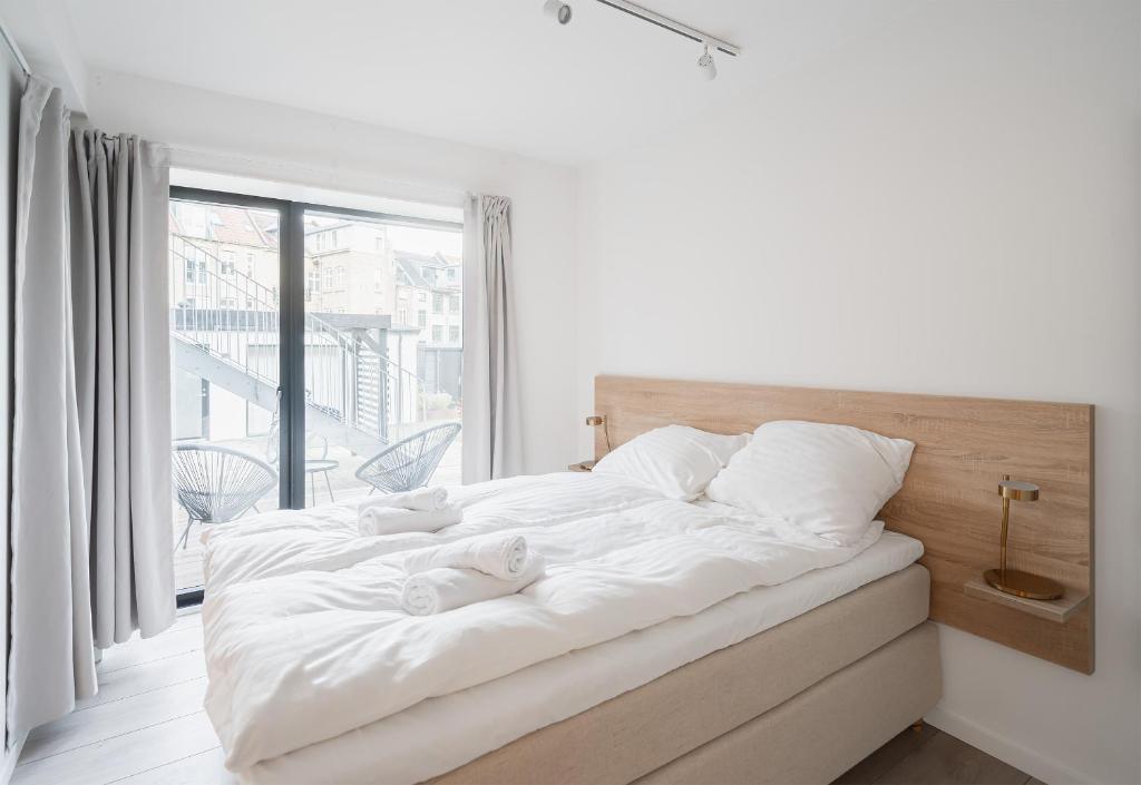 a bedroom with a large white bed with a window at Fantastic apartment wprivate terrace in Aarhus