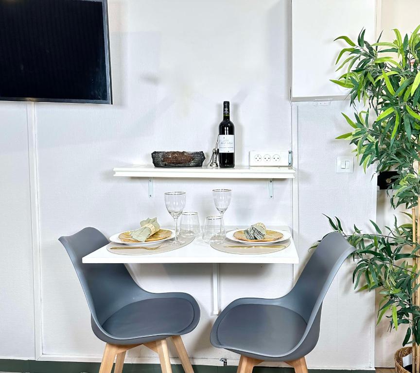 een tafel met 2 stoelen en een fles wijn bij 5496 - Studio Montparnasse Olympic Games 2024 in Parijs