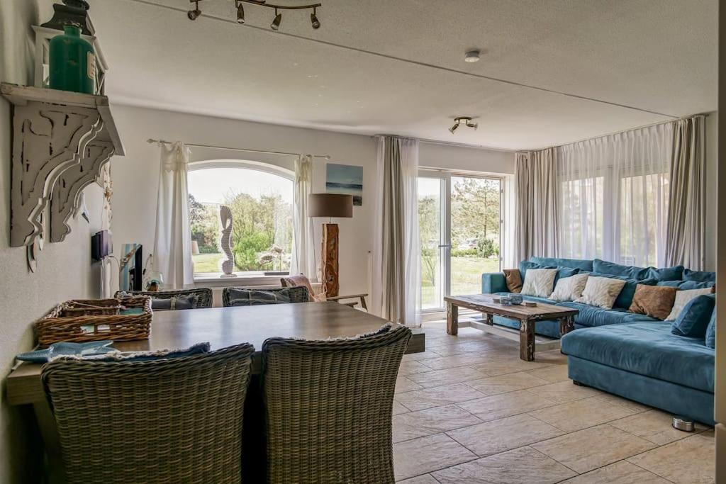 a living room with a blue couch and a table at Appartement Regina - Residence Juliana Julianadorp aan Zee in Julianadorp