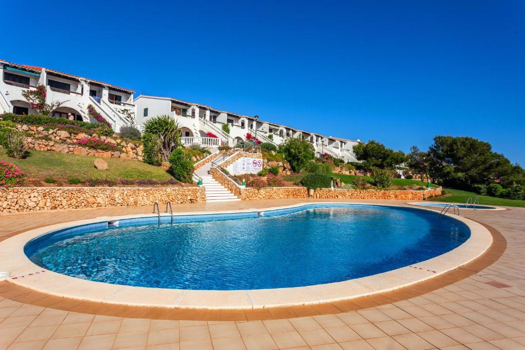 a large swimming pool in the middle of a resort at Apartamento Arenal de'n Castell in Arenal d'en Castell