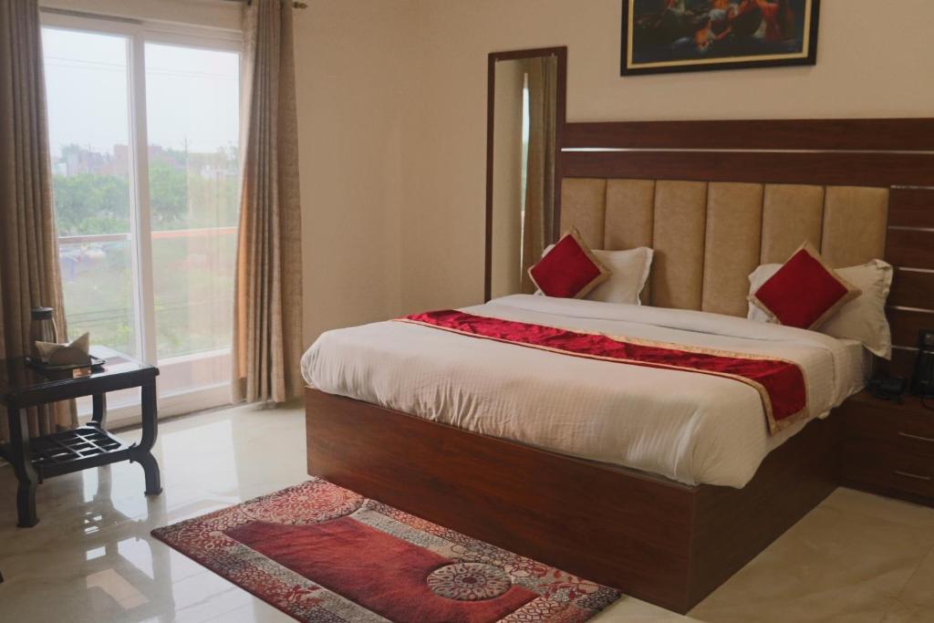 1 dormitorio con 1 cama grande y ventana grande en Guru Kripa sadan, en Vrindāvan