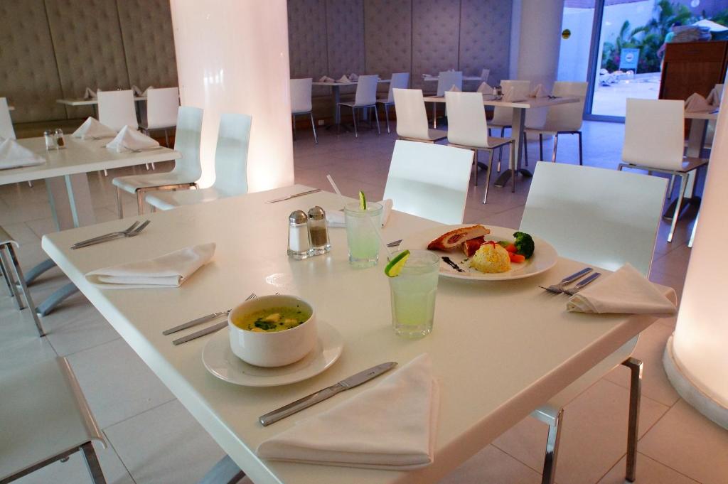 a table with a bowl of soup and a plate of food at Adhara Express in Cancún