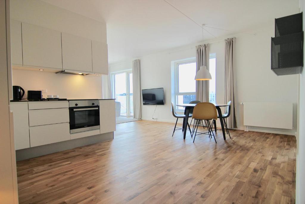 a kitchen and dining room with a table and chairs at Stunning 2-bed wbalconies and beautiful views in Copenhagen