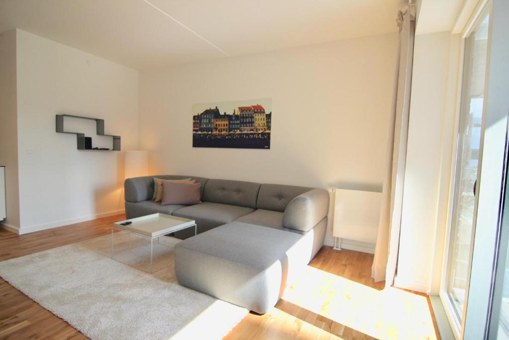 uma sala de estar com um sofá e uma mesa em Fantastic 2-bed w balcony in Ørestaden em Copenhague