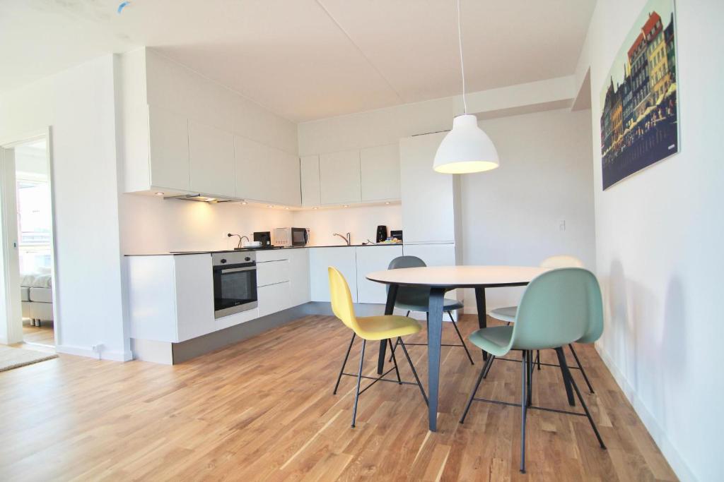 a kitchen and dining room with a table and chairs at Great 2-bed w balconies and awazing views in Copenhagen