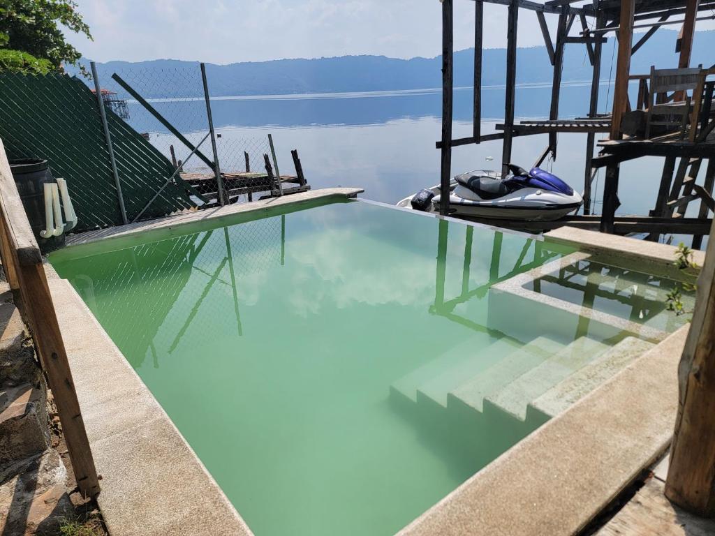 duży basen z błękitną wodą obok jeziora w obiekcie Restaurante y Hostal Romayor w mieście Santa Ana