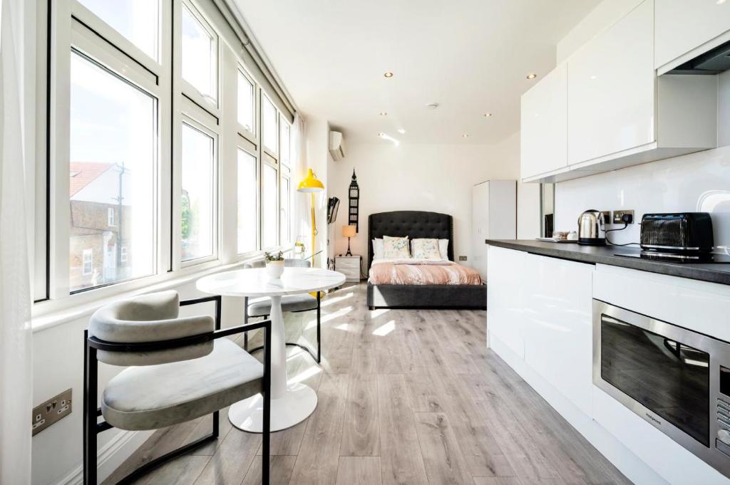 ロンドンにあるCity studios londonのキッチンとテーブルとソファのあるリビングルーム