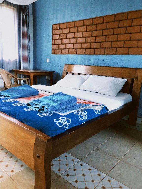 Bett in einem Schlafzimmer mit blauer Wand in der Unterkunft Vineyard Retreat Voi in Voi