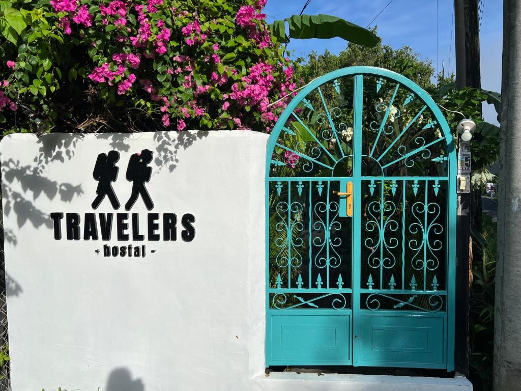 um portão com um sinal que lê viajantes niki em Hostel Travelers Santiago em Santiago