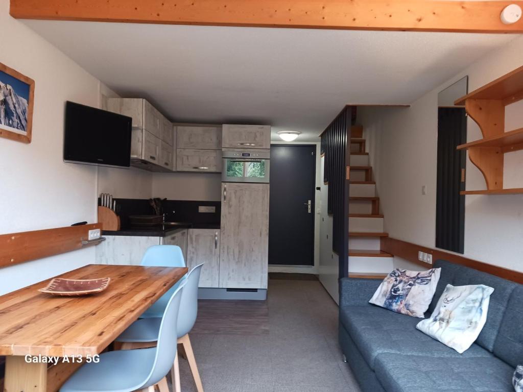 une petite maison avec une table à manger et un canapé dans l'établissement Appartement 3P 6 pers Arc 1800 au pied des pistes avec balcon et équipements complets - FR-1-411-917, à Bourg-Saint-Maurice