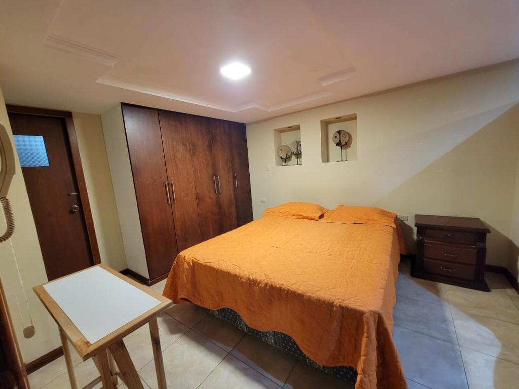 a bedroom with a bed and a wooden cabinet at Maria minidepartamento Loja in Loja
