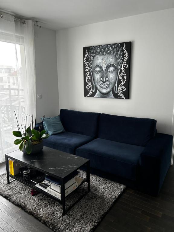 un salon avec un canapé bleu et une table dans l'établissement Modern appartement, à Nogent-sur-Marne