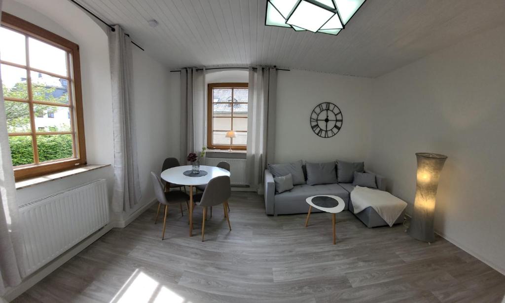 uma sala de estar com um sofá e uma mesa em Ferienwohnung Frauenmarkt em Schneeberg