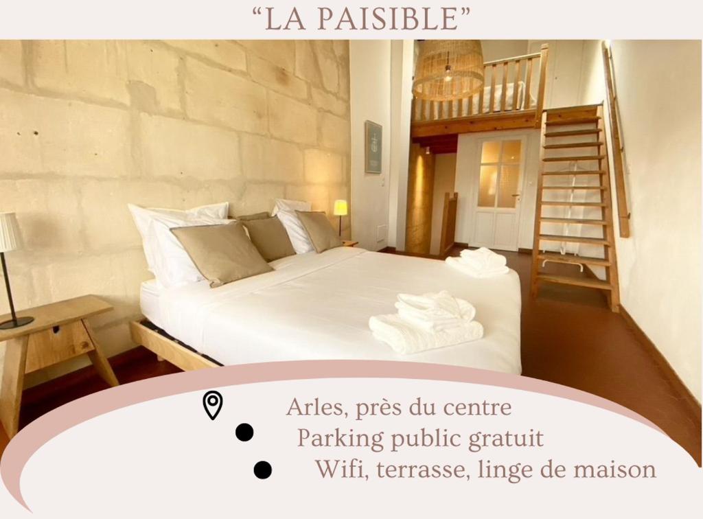 a bedroom with a white bed and a spiral staircase at "La paisible" Maison vue sur le Rhône Arles in Arles
