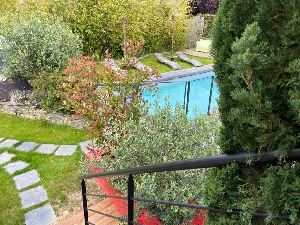 uma vista para um jardim com uma piscina em Les Logis du Forgeron em Saint-Jean-des-Mauvrets