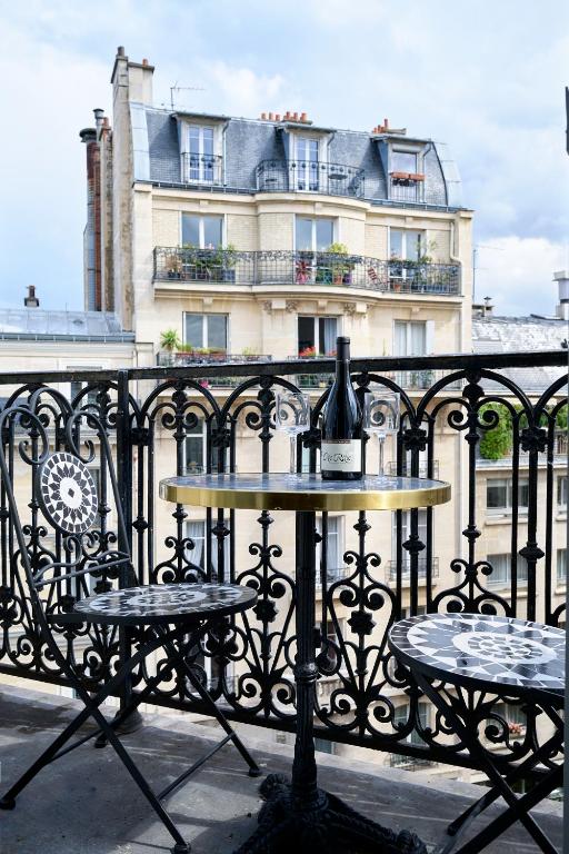 une bouteille de vin posée sur une table sur une clôture dans l'établissement Studio design tout équipé avec balcon, à Paris