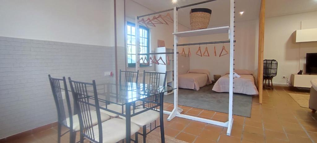 a dining room with a glass table and a bedroom at Casa con finca cerca de playas in Valdoviño