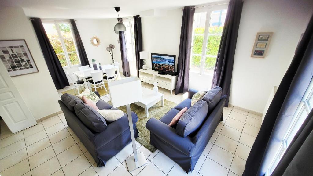 ein Wohnzimmer mit 2 blauen Stühlen und einem Tisch in der Unterkunft Disneyland Paris Modern Villa in Bailly-Romainvilliers
