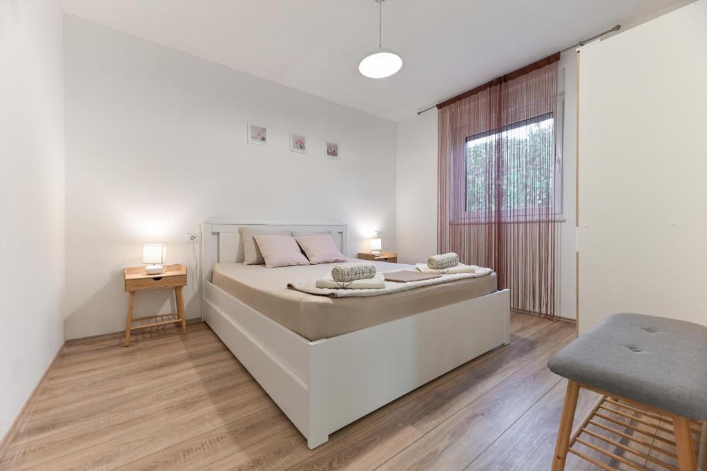 Un dormitorio blanco con una cama grande y una ventana en Holiday home Aprilis with pool, jacuzzi and sauna, en Galovac