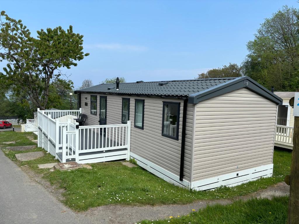 a tiny house with a porch and a fence at KMC-Country Breaks Bideford Bay At Glade in Bucks Mills