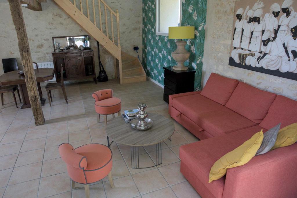 un salon avec un canapé, des chaises et une table dans l'établissement La Parenthèse Girondine, à Pujols Gironde