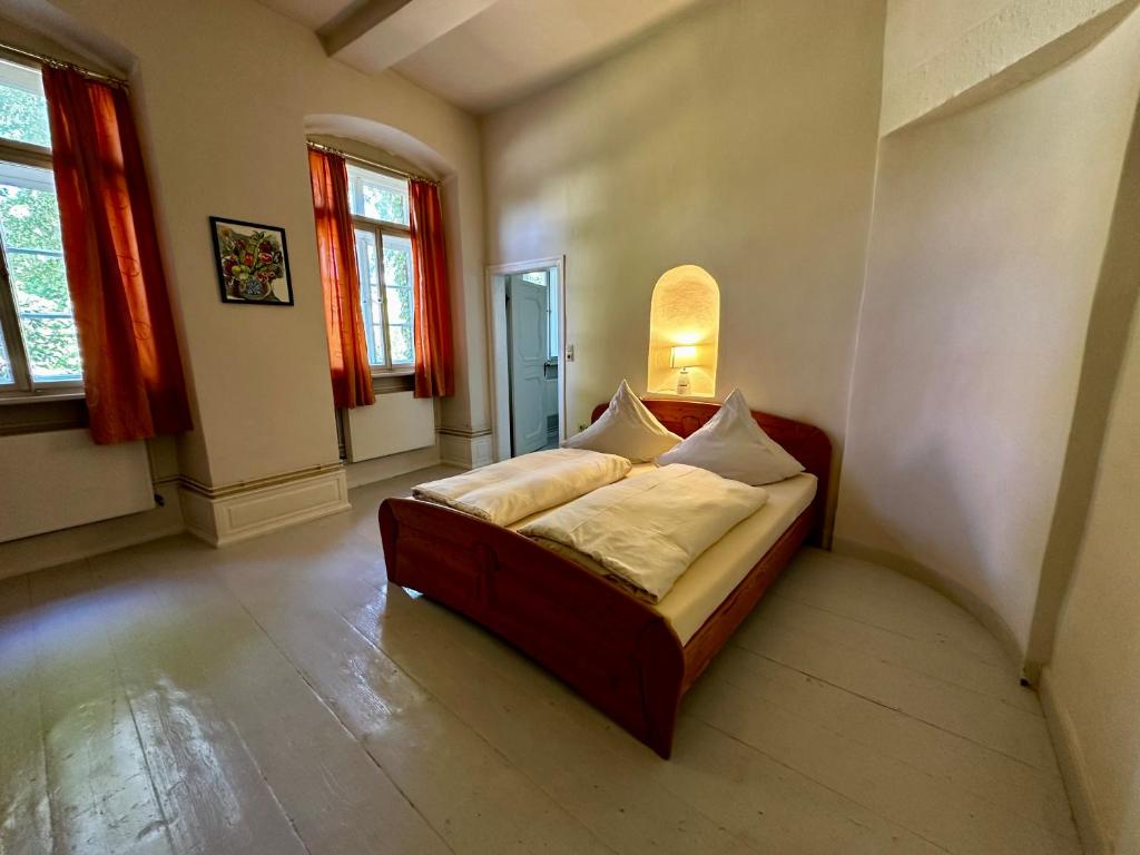 een slaapkamer met een bed in een kamer met ramen bij Kloster Malgarten in Bramsche